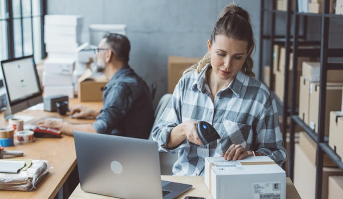 Egy párnára helyezett laptopon gépelő személy